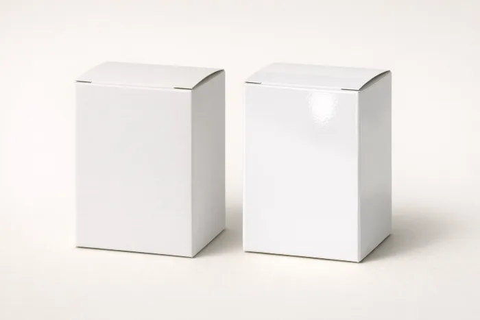 Two identical blank cartons under the same light: the left matte and glare-free, the right glossy with a bright specular highlight.