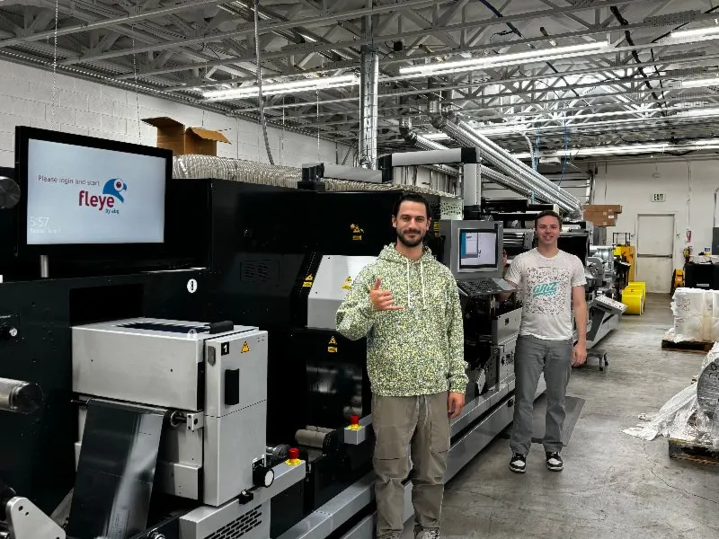 A Calyx converting line on the production floor, with two team members beside the press